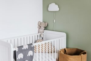 Modern baby room featuring a white crib, soft decor, and pastel accents.